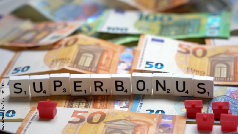 Scritta Superbonus con banconote e casette rosse